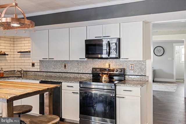 kitchen with white cabinetry, stainless steel appliances, and crown molding