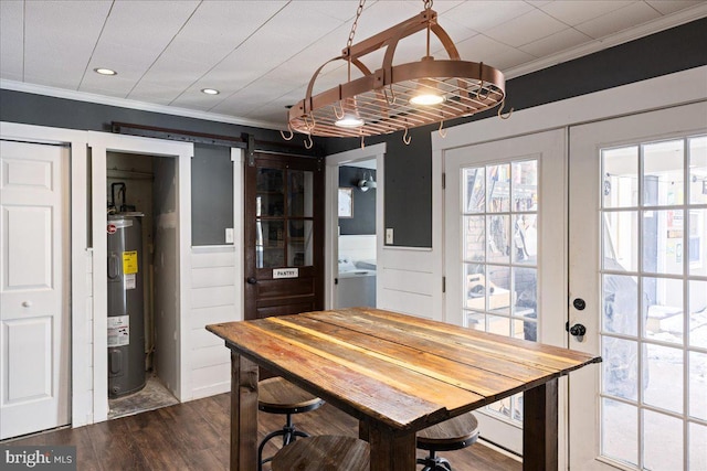 dining room featuring water heater, dark hardwood / wood-style flooring, crown molding, a barn door, and french doors