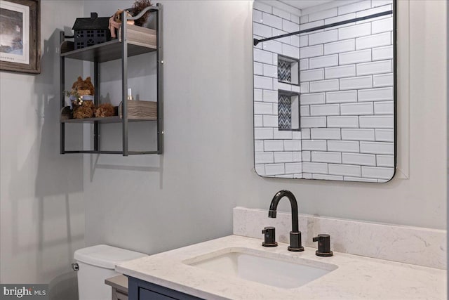 bathroom with vanity, toilet, and a tile shower