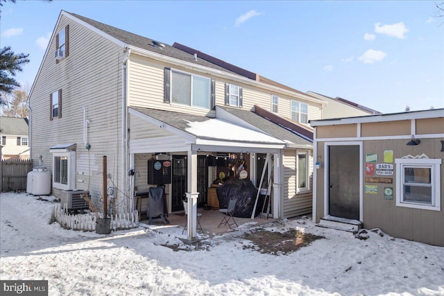 snow covered house with central AC