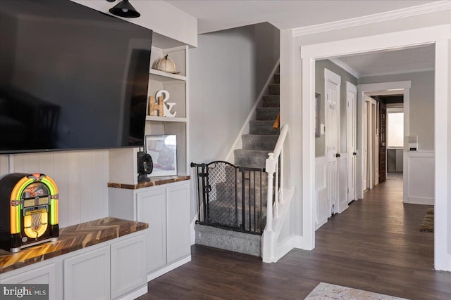 stairs with hardwood / wood-style flooring and crown molding