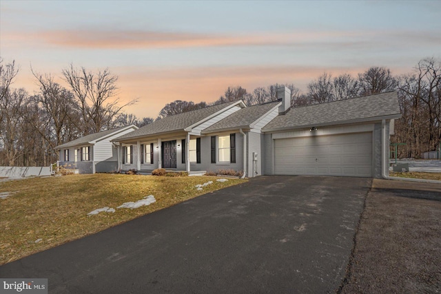 single story home featuring a yard and a garage