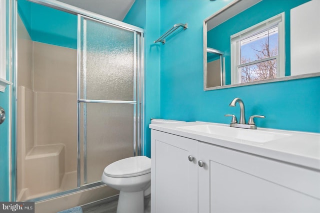 bathroom with vanity, a shower with shower door, wood-type flooring, and toilet