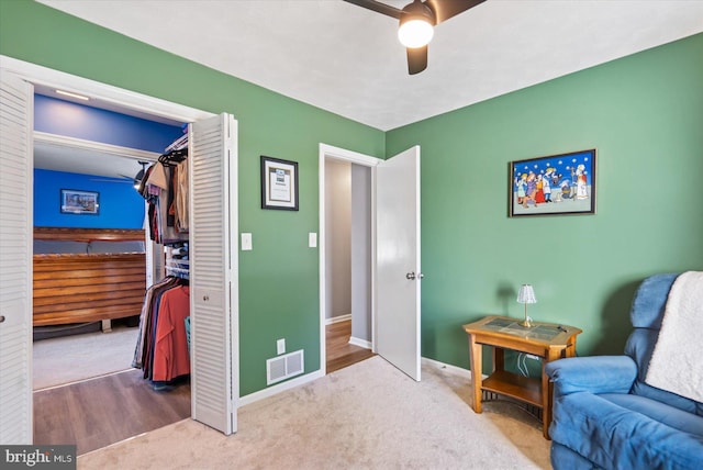 living area with carpet flooring and ceiling fan