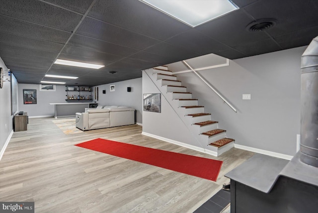 interior space with a drop ceiling and hardwood / wood-style floors