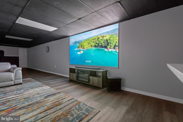 home theater room with wood-type flooring and a drop ceiling