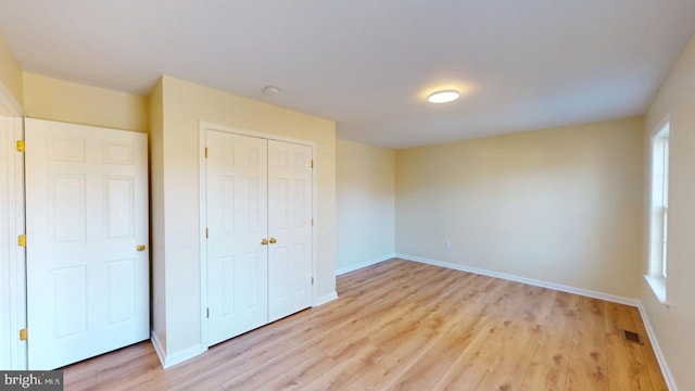 unfurnished bedroom featuring light hardwood / wood-style floors and a closet