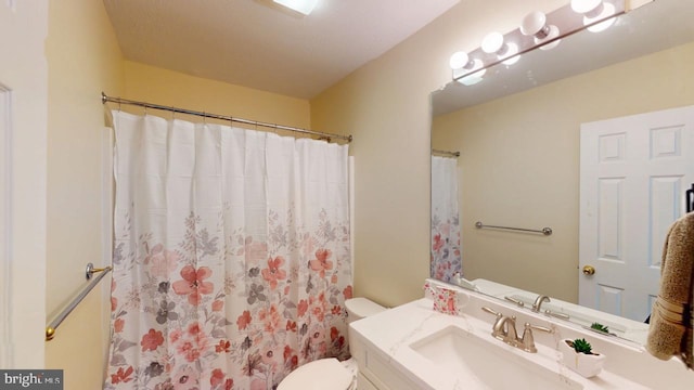 bathroom featuring vanity, toilet, and curtained shower