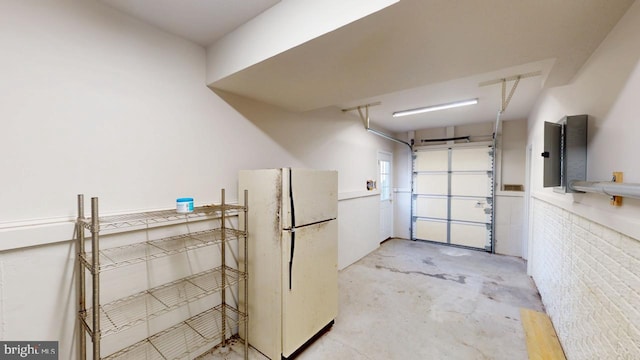 garage featuring white refrigerator and electric panel