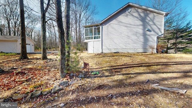 view of home's exterior with a garage and a sunroom