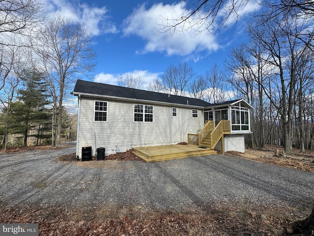 back of house featuring a wooden deck, a sunroom, and central AC unit