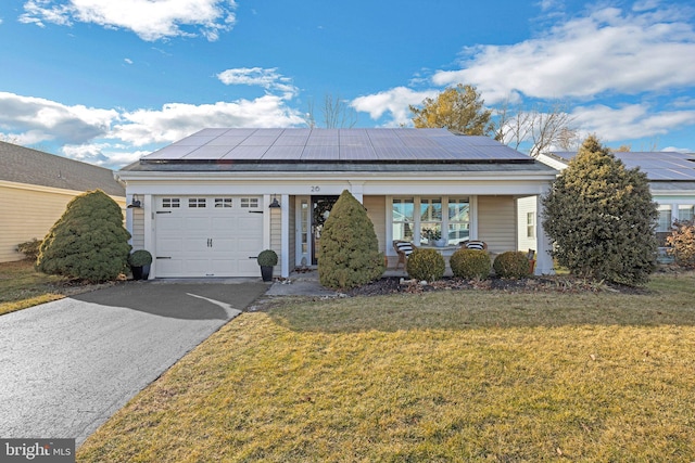 view of front of property with a garage, a front lawn, solar panels, and covered porch