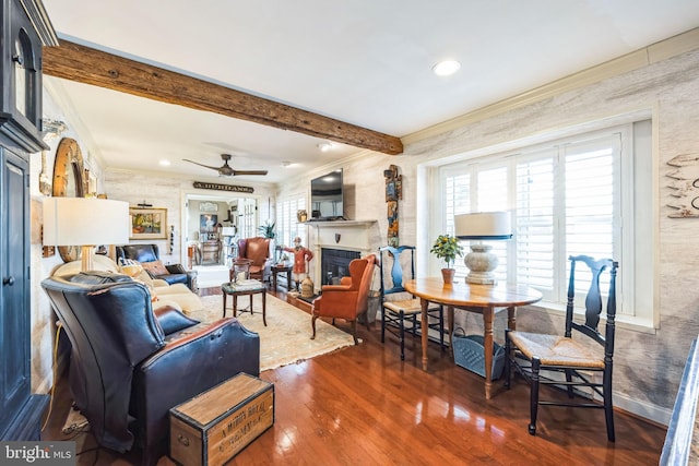 living room featuring ceiling fan, ornamental molding, dark hardwood / wood-style floors, and beamed ceiling