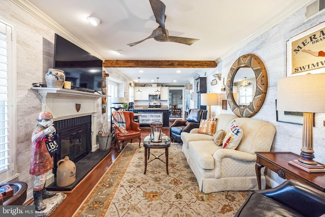 living room featuring hardwood / wood-style flooring, ceiling fan, ornamental molding, and a healthy amount of sunlight