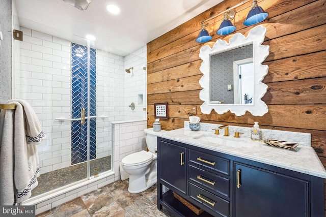 bathroom featuring vanity, toilet, and a shower with shower door