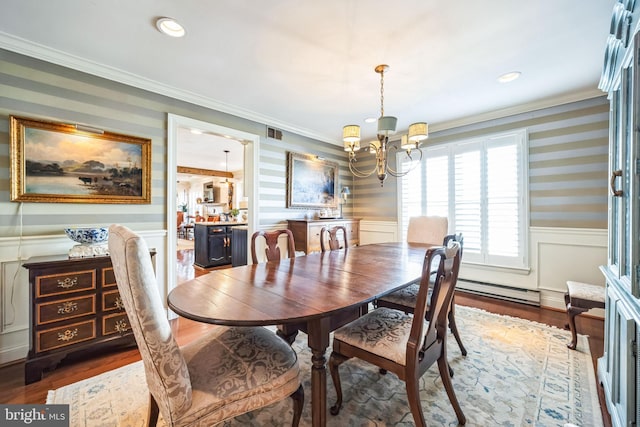 dining room featuring dark hardwood / wood-style flooring, a baseboard heating unit, crown molding, and a notable chandelier