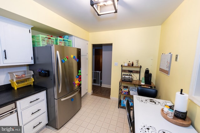 kitchen featuring white cabinetry, light tile patterned floors, and stainless steel refrigerator