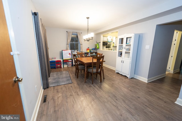 dining area featuring a chandelier and dark hardwood / wood-style flooring