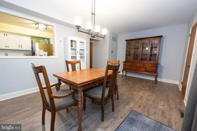 dining area featuring dark hardwood / wood-style flooring and a chandelier