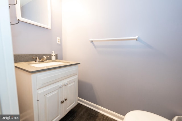 bathroom featuring vanity, hardwood / wood-style floors, and toilet