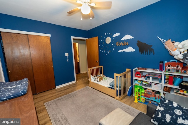 bedroom with hardwood / wood-style flooring, ceiling fan, and a closet