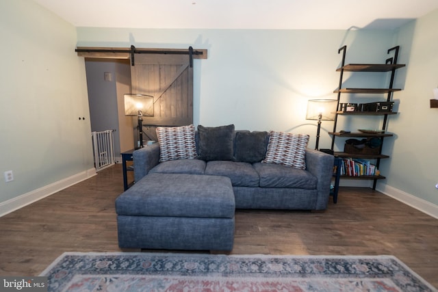 living room with a barn door and dark hardwood / wood-style floors