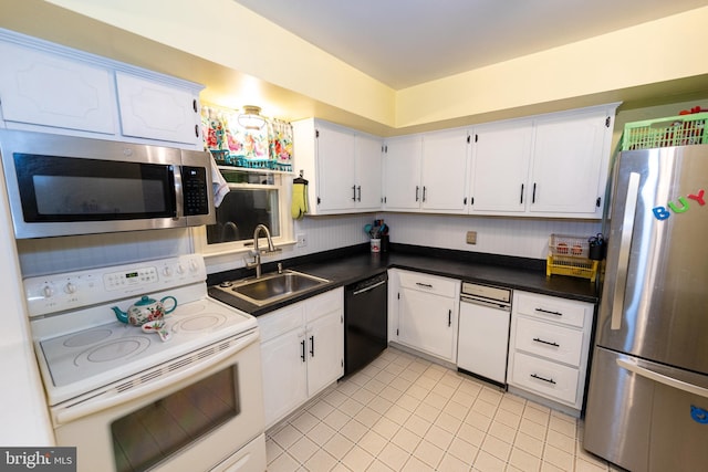 kitchen featuring appliances with stainless steel finishes, sink, light tile patterned floors, and white cabinets