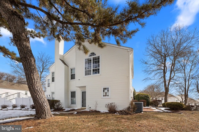 view of front of home with central AC and a front lawn