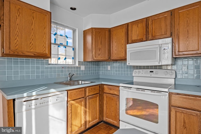 kitchen featuring parquet floors, white appliances, sink, and tasteful backsplash