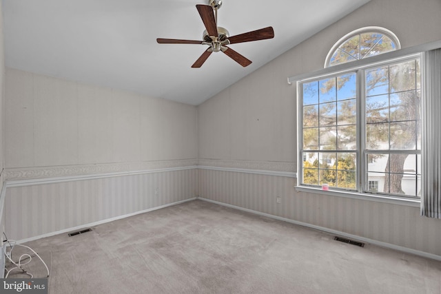 carpeted empty room featuring lofted ceiling and ceiling fan