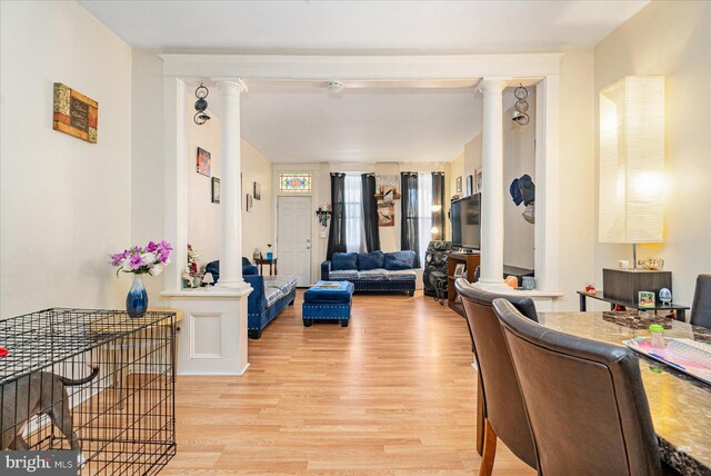 living room with ornate columns and light wood-type flooring