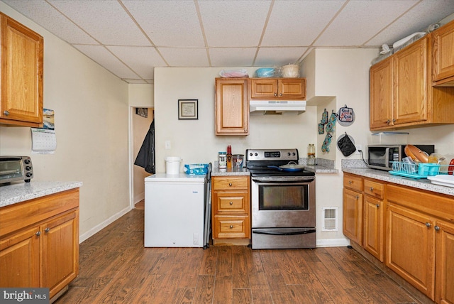 kitchen featuring dark wood-type flooring, stainless steel appliances, and a paneled ceiling