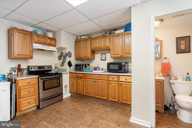 kitchen with a paneled ceiling, appliances with stainless steel finishes, and dark hardwood / wood-style floors