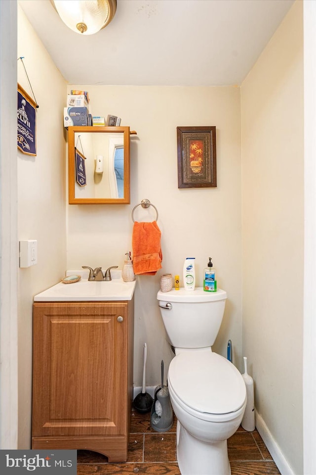 bathroom featuring wood-type flooring, toilet, and vanity