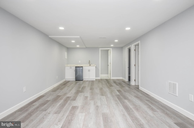 unfurnished living room with light hardwood / wood-style floors and indoor wet bar