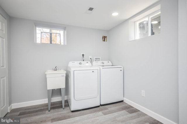 washroom featuring washer and clothes dryer and light hardwood / wood-style floors