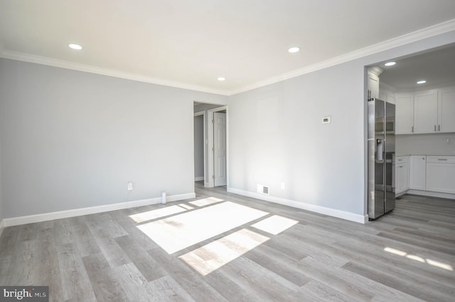 empty room with crown molding and light hardwood / wood-style flooring