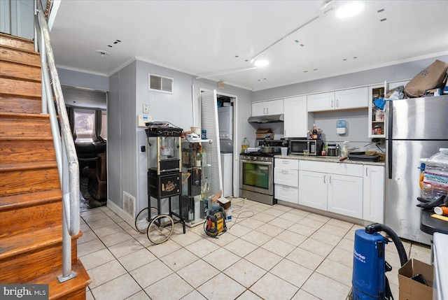 kitchen featuring white cabinetry, crown molding, stainless steel appliances, and dark stone countertops