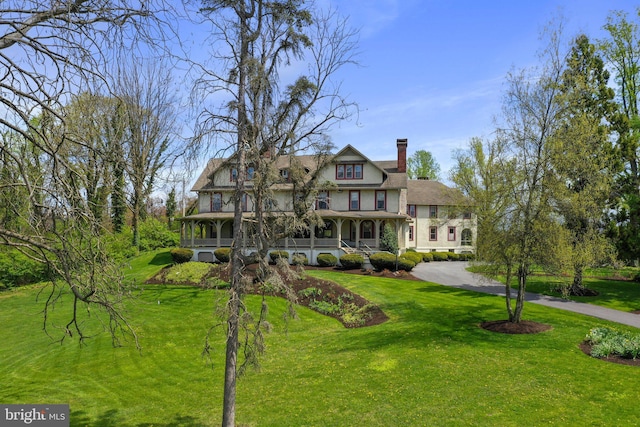 victorian house featuring covered porch and a front yard