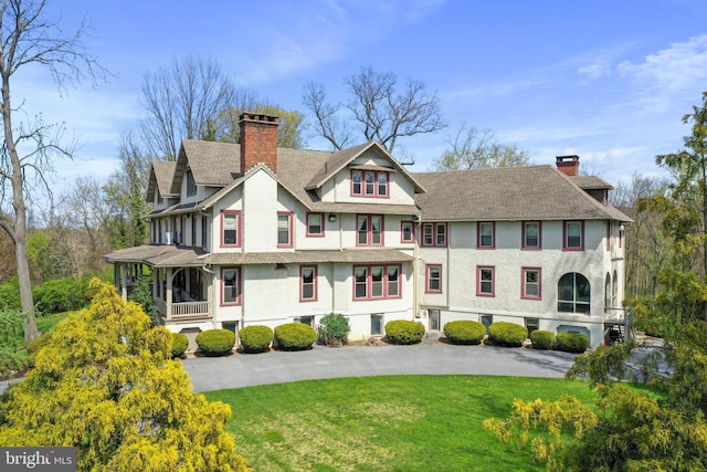 rear view of house featuring a lawn