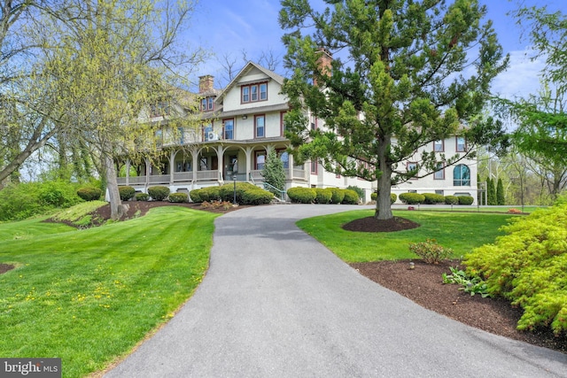 view of front facade featuring a front yard and covered porch