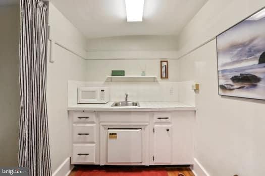 interior space with sink, white cabinets, and dark hardwood / wood-style floors