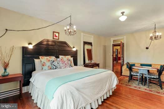 bedroom featuring hardwood / wood-style flooring and a notable chandelier