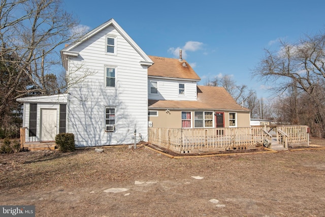 rear view of house with cooling unit and a deck