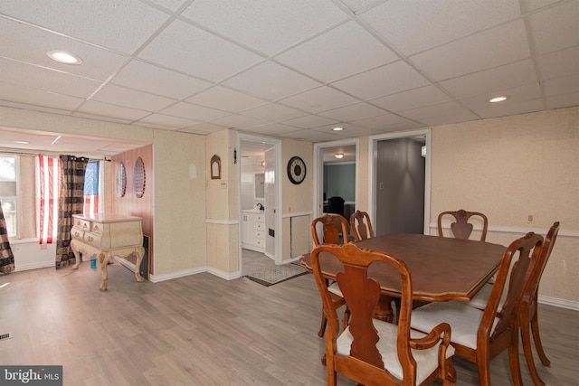 dining area featuring hardwood / wood-style flooring and a paneled ceiling