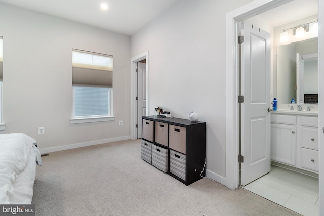 carpeted bedroom featuring ensuite bath