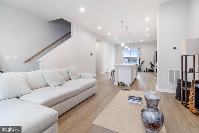 living room with sink and light hardwood / wood-style flooring