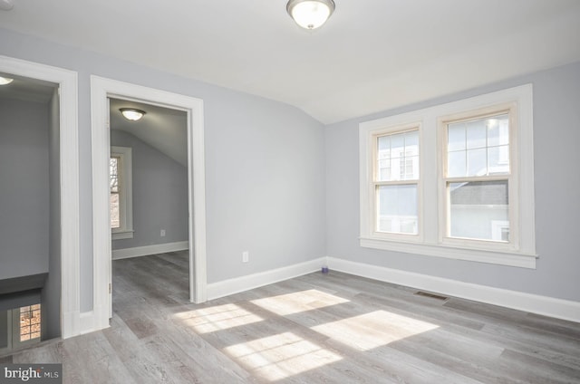 unfurnished room with vaulted ceiling and light hardwood / wood-style floors