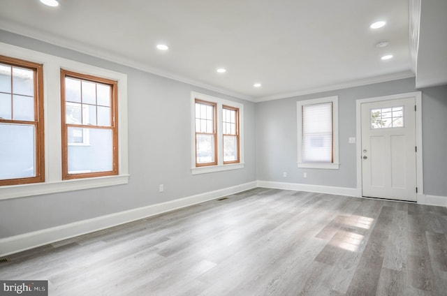 foyer entrance with crown molding and light hardwood / wood-style flooring