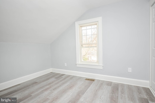 additional living space featuring lofted ceiling and light hardwood / wood-style floors